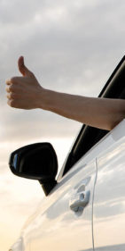 person giving thumbs up out car windo
