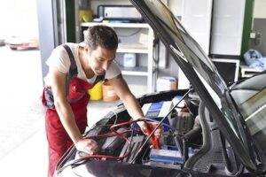 auto mechanic working on car battery repair